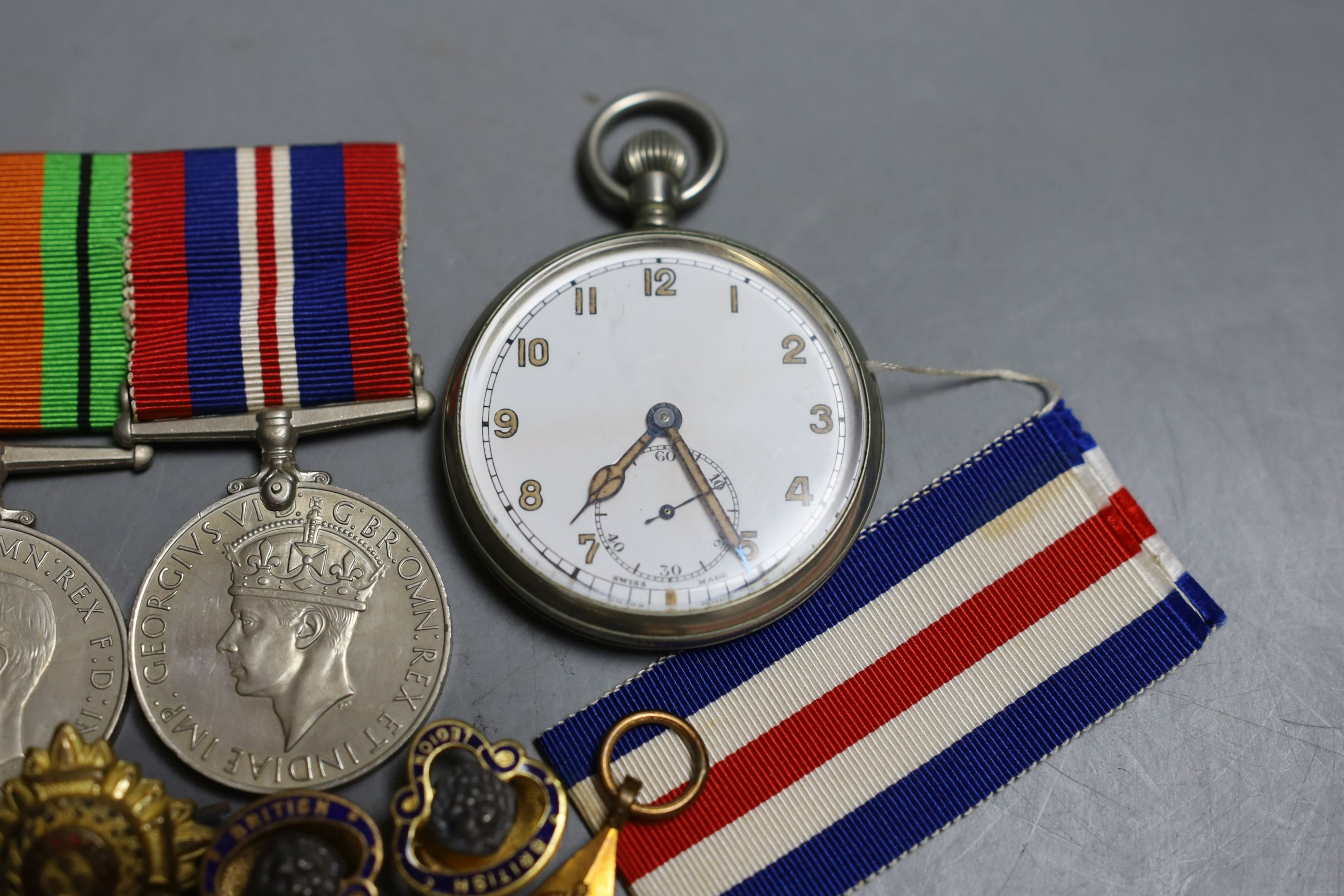 A group of five WW2 medals, together with a selection of cap badges and a GS Mk.II pocket watch